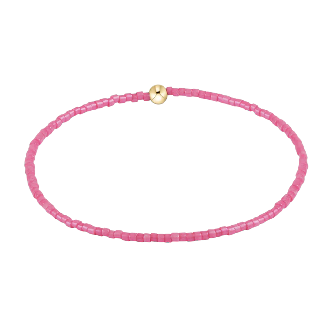 Pink beaded bracelet with a gold clasp on a white background