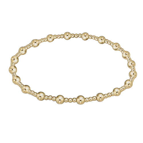 Gold beaded bracelet on a light beige background