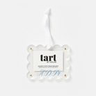A clear scalloped acrylic hanging ornament with a white paper insert card that reads 'tart BY TAYLOR' and 'MAGNETIC PHOTO FRAME ORNAMENT,' shown on a light gray background.