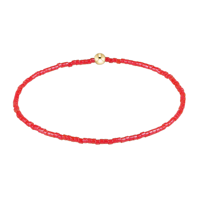 Red beaded bracelet with a gold clasp on a white background