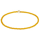 A yellow beaded bracelet with a small gold-toned circular clasp, displayed on a clean white background.