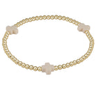 Gold beaded bracelet with beige cross charms on a light gray background