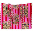 Fabric with tiger pattern on a red and pink striped background against a brick wall.