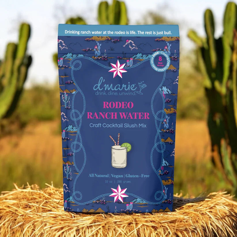 d'marie Rodeo Ranch Water mix packet on a hay bale with cacti in the background