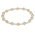 A two-tone beaded stretch bracelet featuring textured gold and polished silver beads, arranged in an oval shape on a clean white background.
