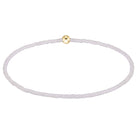 A delicate beaded bracelet with small, translucent pale lavender beads and a single polished gold clasp, shown on a clean white background.