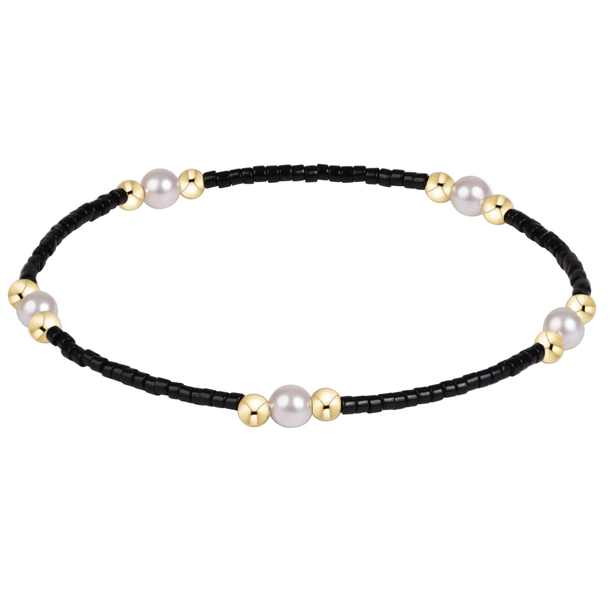 A delicate beaded bracelet featuring a black bead chain accented with large white pearls and polished gold spacer beads, displayed on a clean white background.
