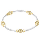 A two-tone beaded bracelet featuring textured gold and polished silver beads, arranged in an oval shape on a solid white background.